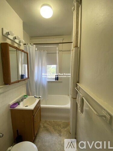 A bathroom with a toilet, sink, and bathtub.