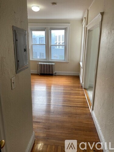 A hallway with wood floors and white walls.