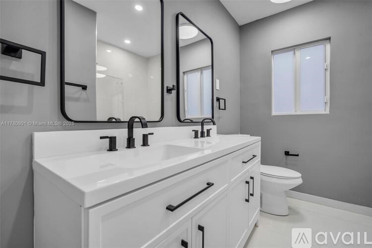 A bathroom with a white sink and a toilet.