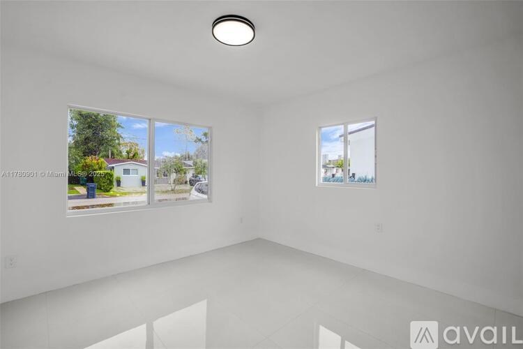 A white room with two windows and a ceiling light.