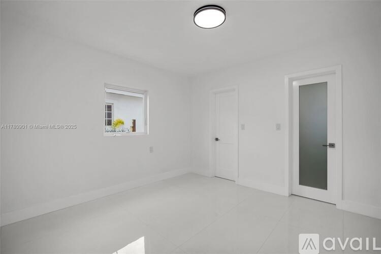 A white room with a door and a window.