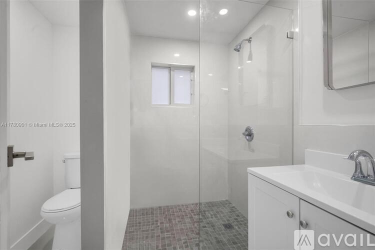 A bathroom with a toilet, sink, and shower.
