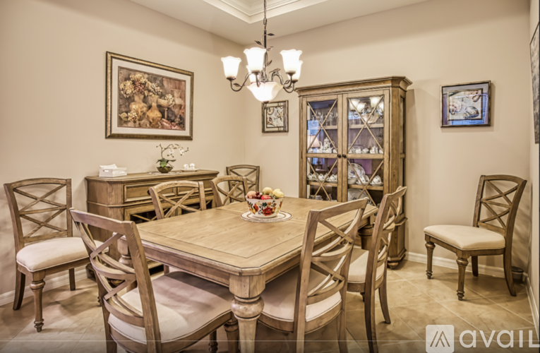 A dining room with a wooden table and chairs.