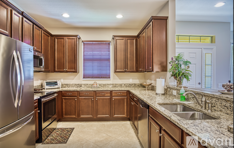 A kitchen with brown cabinets and a stainless steel refrigerator.