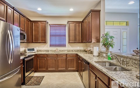A kitchen with brown cabinets and a stainless steel refrigerator.