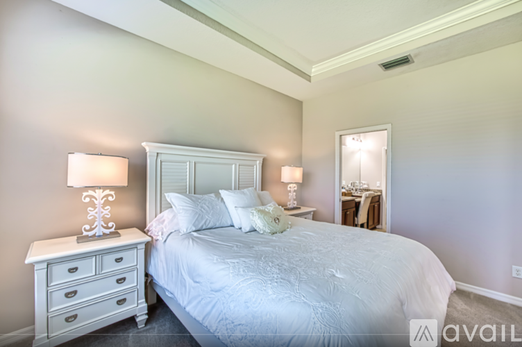 A bedroom with a large bed and two lamps.