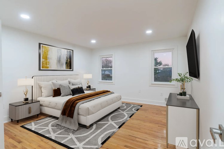 A bedroom with a large bed and a flat screen TV mounted on the wall.