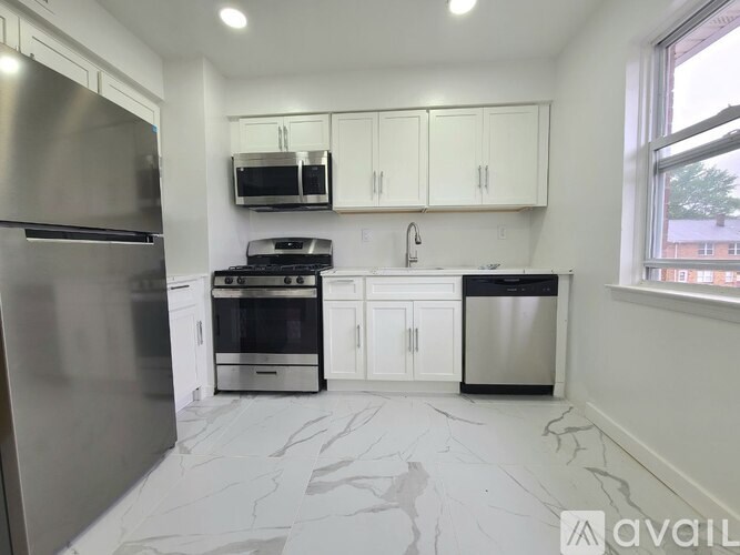 A kitchen with a stainless steel refrigerator, microwave, oven, and cabinets.