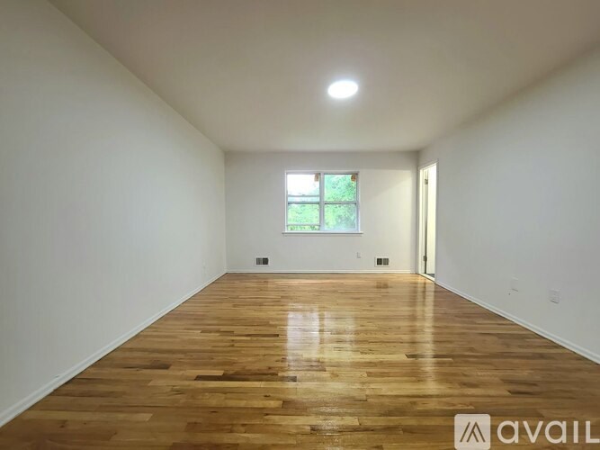 A room with wooden flooring and a window.