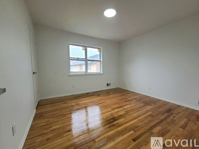 A room with wooden flooring and a window.