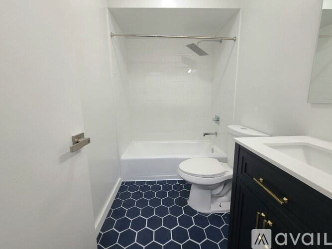 A bathroom with a white toilet and a black and white tiled floor.