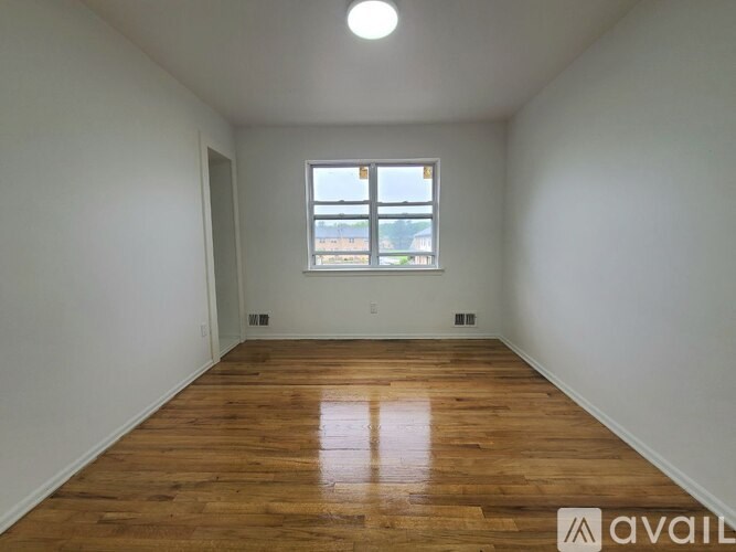 A room with wooden flooring and a window.