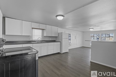 A modern kitchen with white cabinets and a black dishwasher.