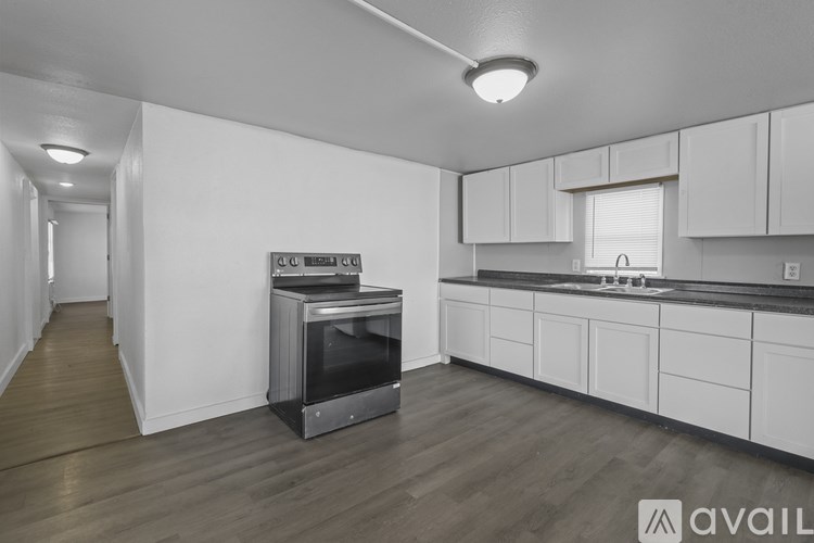 A kitchen with white cabinets and a black countertop.