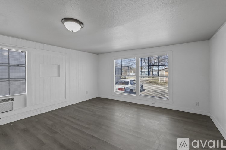 A room with a window showing a parking lot outside.