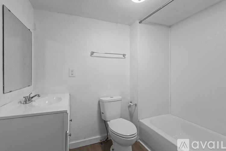 A white bathroom with a toilet, sink, and bathtub.