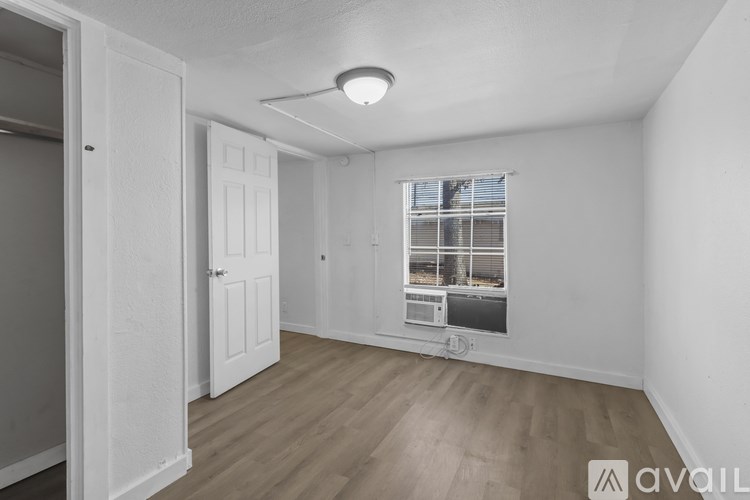 A room with a window and a wooden floor.