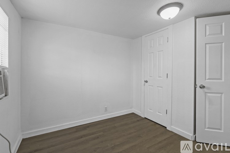 A room with a white door and a window with blinds.