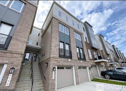 A modern apartment building with a car parked in the driveway.