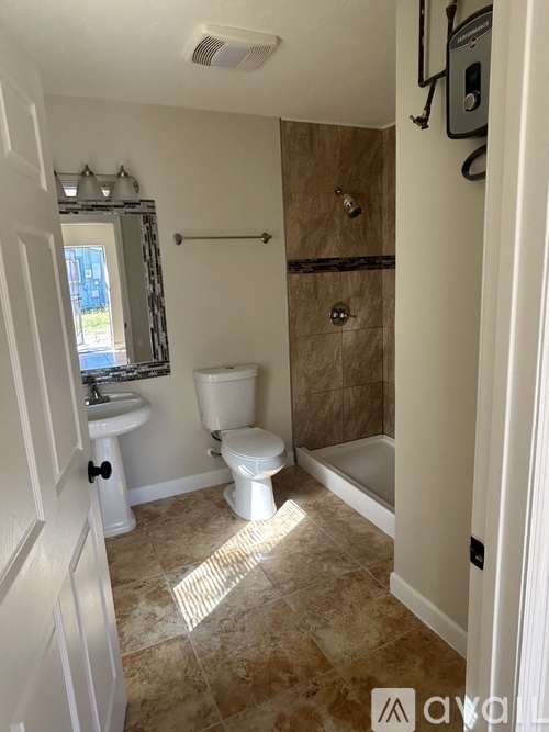 A bathroom with a toilet, sink, and shower.