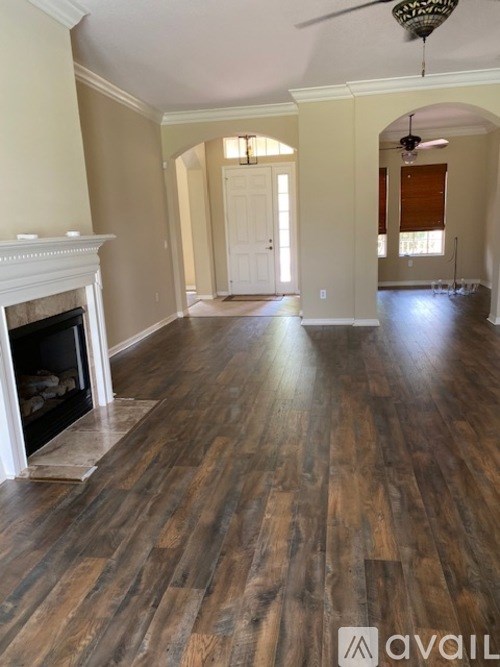 A room with a fireplace and wood flooring.