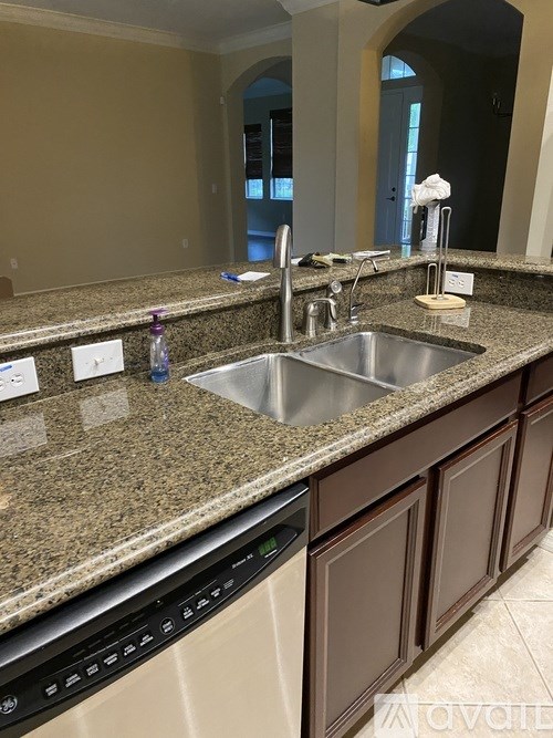 A kitchen with granite countertops and a stainless steel sink.