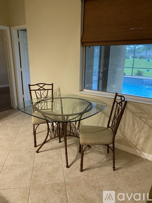 A glass table with two chairs in a room.