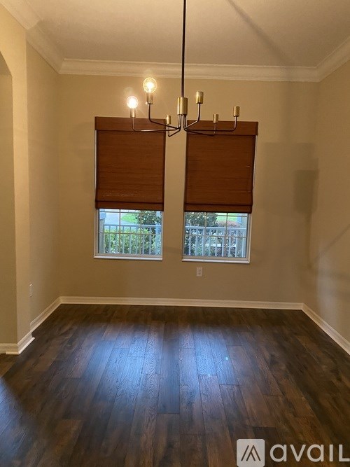 A room with wooden floors and a window with blinds.