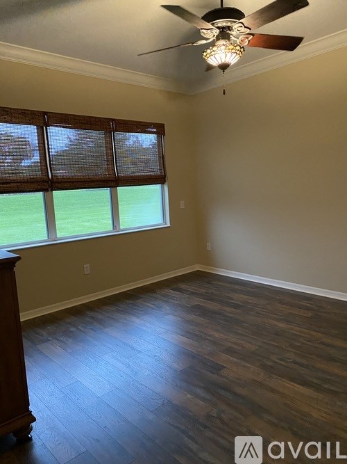 A room with wooden floors and a ceiling fan.