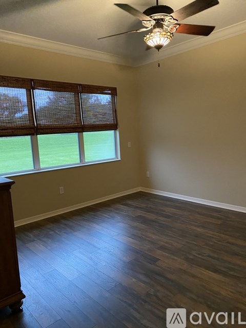 A room with wooden floors and a ceiling fan.