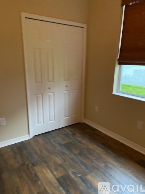 A white door is in a room with a wooden floor.