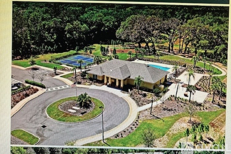 A large house with a pool and a circular driveway.