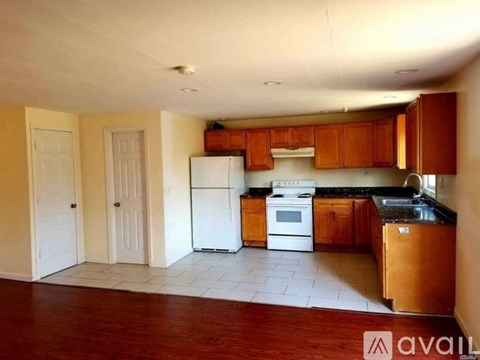 A kitchen with wooden cabinets and a white refrigerator.