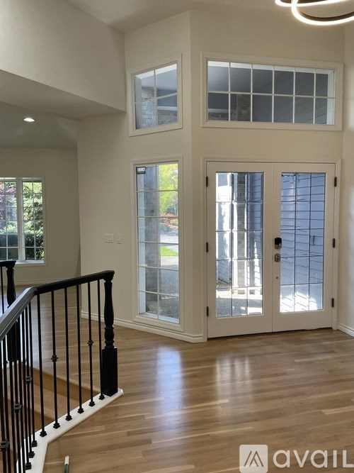 A large open space with a staircase and a glass door leading to a balcony.