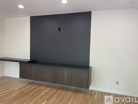 A room with a black wall and a wooden floor.