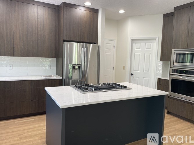 A modern kitchen with dark wood cabinets and white countertops.