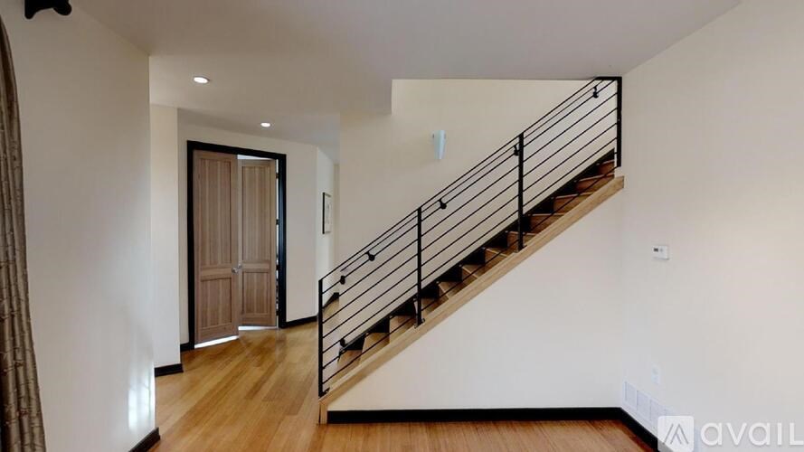 A wooden staircase with a metal railing leads to an upper level.