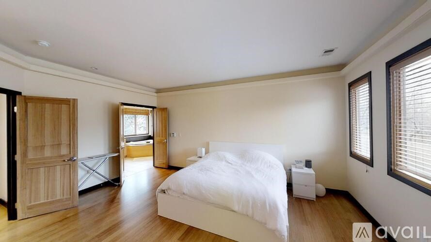 A bedroom with a large bed and wooden floors.