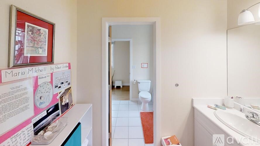 A bathroom with a sink, toilet, and mirror.