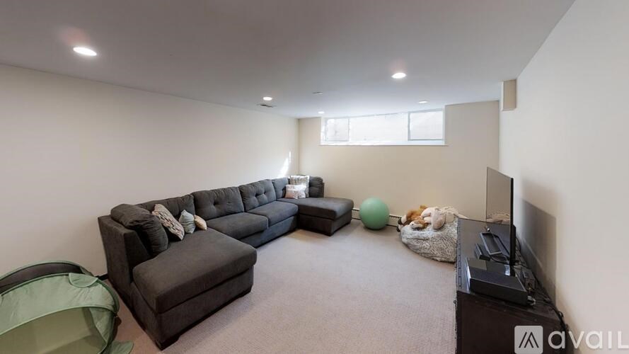 A living room with a grey sofa and a television.