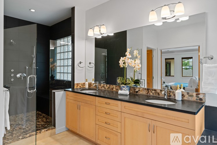 A bathroom with a vanity, sink, and mirror.