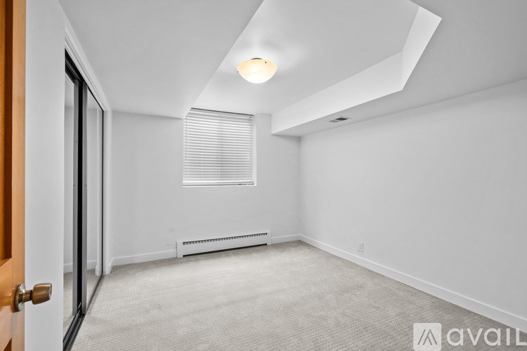 A room with a window covered by blinds and a ceiling light.