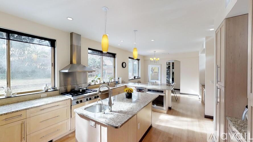 A modern kitchen with a large island and stainless steel appliances.
