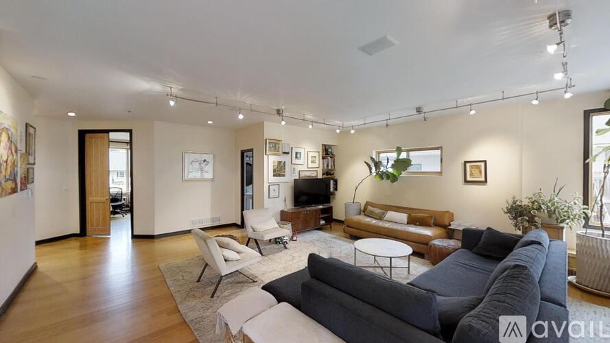 A living room with a grey couch and a white chair.