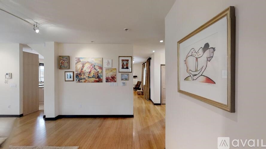 A hallway with a painting on the wall and a few other paintings on the wall.