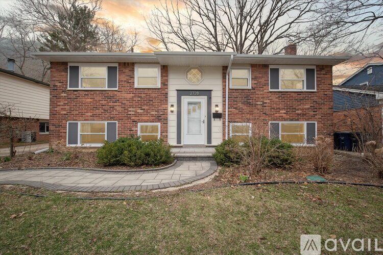 A house with a white door and a brick facade is for sale.