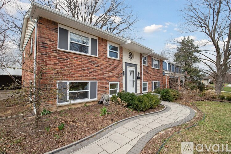 A brick house with a white door and windows.