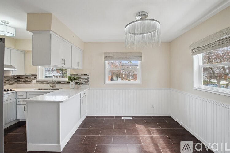 A kitchen with white cabinets and a large island.