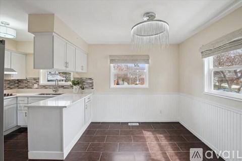A kitchen with white cabinets and a large island.