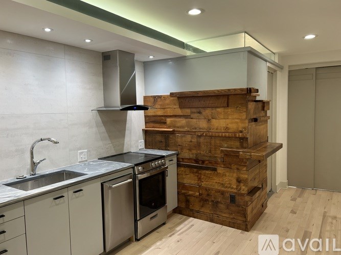 A modern kitchen with a wooden staircase built into the wall.